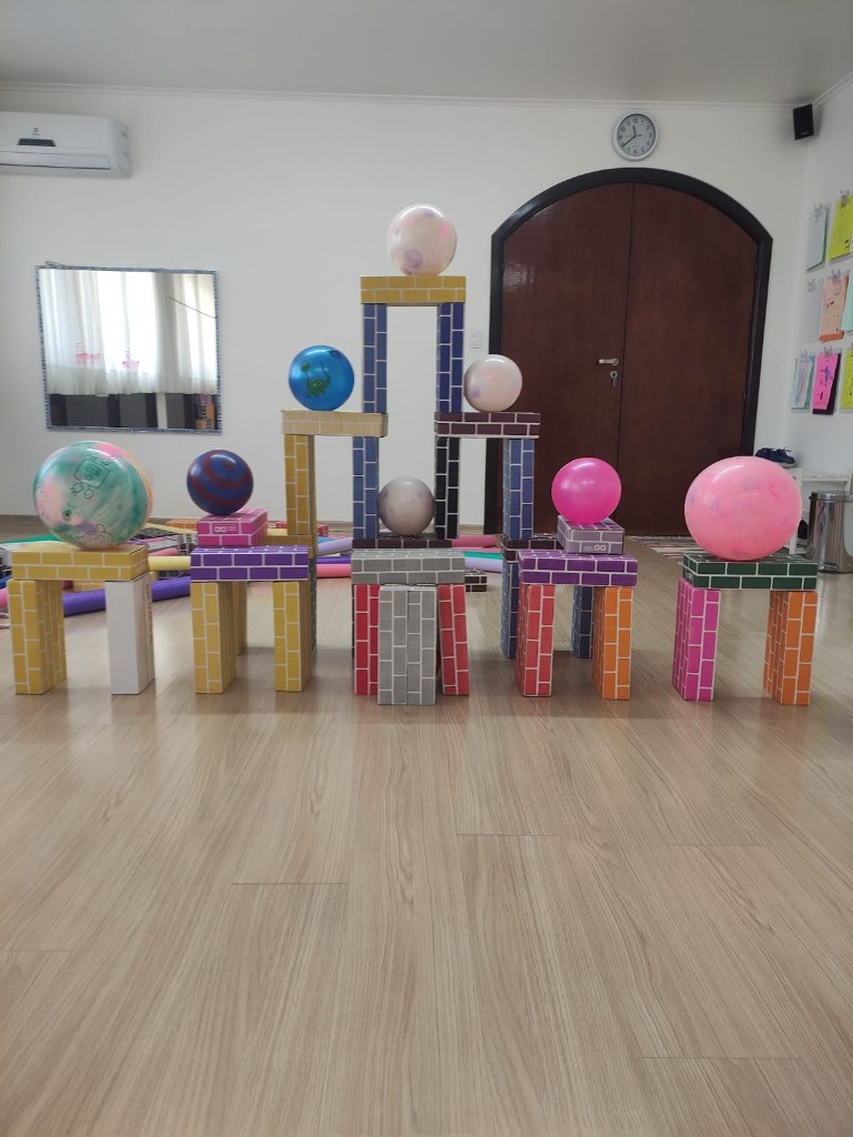 Castelo de tijolos lúdicos com esferas e bolas coloridas equilibradas