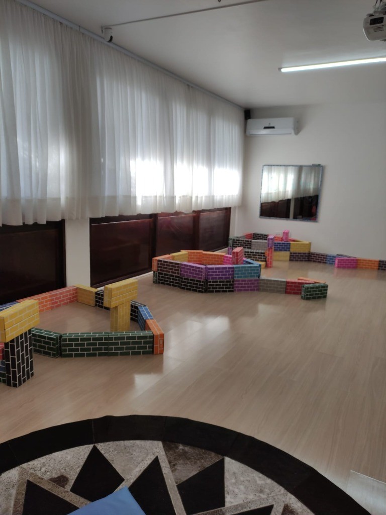 Delimitação de territórios e fortalezas com tijolos lúdicos no chão da sala